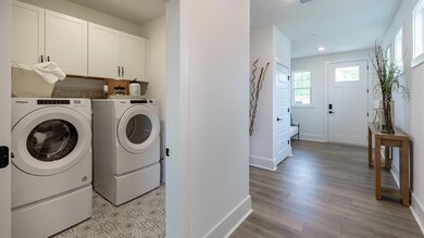 Laundry room featuring cabinet space, independent washer and dryer, baseboards, light wood-style flooring, and recessed lighting