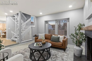 Living room featuring a brick fireplace, stairs, b