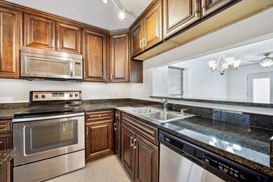 Kitchen with light tile patterned floors, stainle