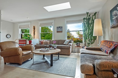 Living room with a skylight and light wood-type flooring