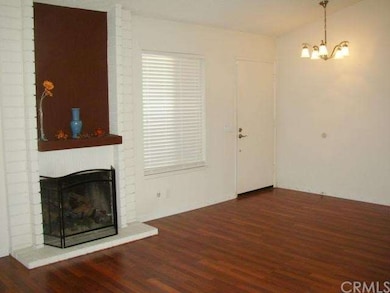 Living room has vaulted ceiling, fireplace, blinds