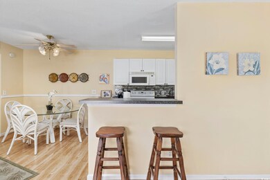 Kitchen featuring white cabinetry, tasteful backsp