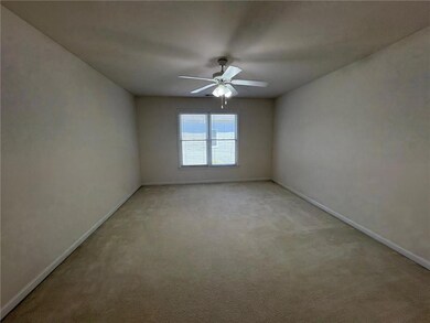 Spare room featuring a ceiling fan, baseboards, an