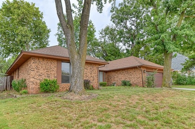 Ranch-style house featuring a garage, a shingled roof, brick siding, and a front lawn