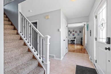 The entry gives a glimpse of several rooms and staircase to the upstairs.