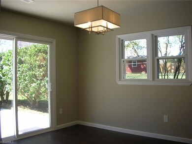 Den: Features include vinyl plank flooring for easy cleaning, a sliding patio door to the private patio, 2 windows for natural lighting and fresh paint. Here we can see the sliding patio door to the left side.