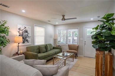 Living area with plenty of natural light, light wood finished floors, a ceiling fan, and recessed lighting