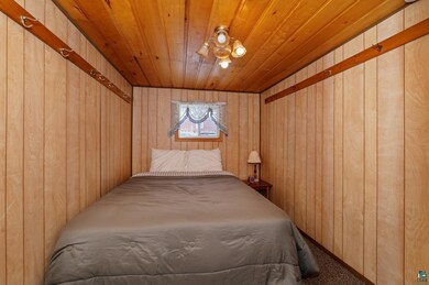 Bedroom featuring wood walls and wood ceiling
