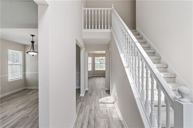 Staircase featuring wood finished floors, a chandelier, and a towering ceiling
