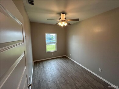 Empty room with dark wood finished floors, ceiling fan, and baseboards