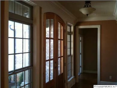 Astounding wood double front door graced with long windows opens into a beautiful foyer with transoms over windows and gleaming hardwood.