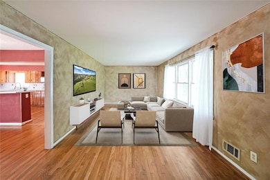 Living area with wood finished floors, healthy amount of natural light, and baseboards