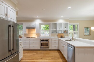 The stunning gourmet kitchen features a five-burner gas range, stainless steel appliances, a generous pantry, a dedicated coffee bar and abundant storage perfect for entertaining.