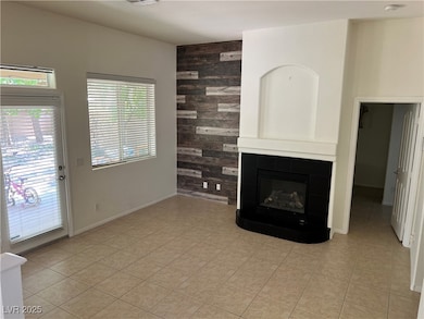 Unfurnished living room featuring wood walls, a tile fireplace, and light tile patterned floors