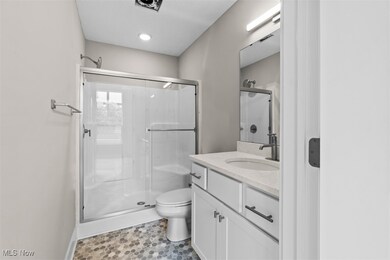 Full bath featuring vanity, a shower stall, and light tile patterned flooring