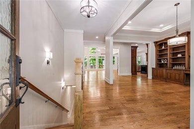 Entrance foyer with crown molding, light wood-type