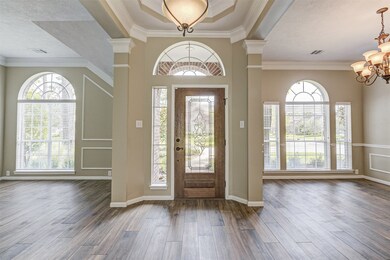 Recently installed beautiful wood tile flooring, wood, beveled glass front door and crown molding make for a grand entrance with light and bright formals on each side.