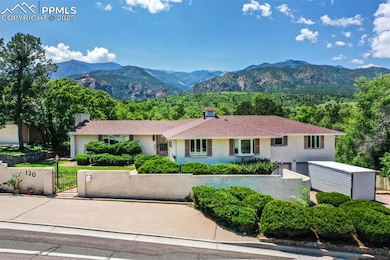 Single story home with a fenced front yard, a gate, a mountain view, an attached garage, and a chimney