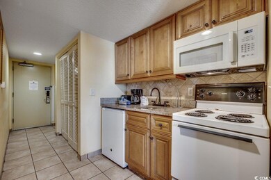 Kitchen with decorative backsplash, white applianc