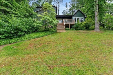 View of grassy yard with stairway and a deck