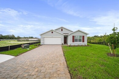 Ranch-style house featuring decorative driveway, an attached garage, and stucco siding