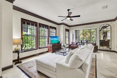 Living room featuring crown molding, light tile pa