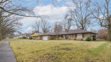 Single story home with a garage and a front lawn