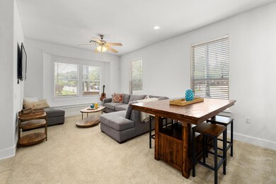 Living area featuring ceiling fan and light color