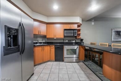 Kitchen with dark countertops, open shelves, a sin