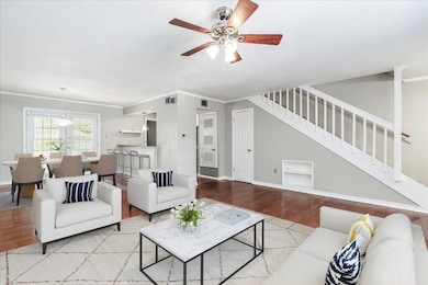 Living room featuring stairway, baseboards, wood 