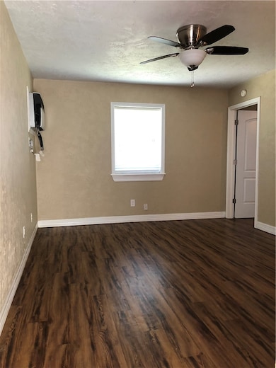 Spare room featuring dark wood-type flooring, base