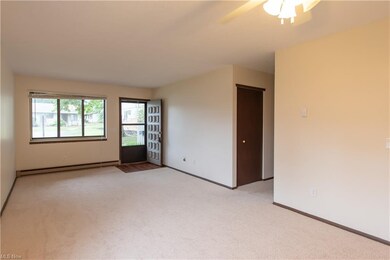 The large, well-lit living room features new carpe