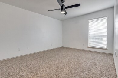 Carpeted empty room featuring baseboards and a ceiling fan