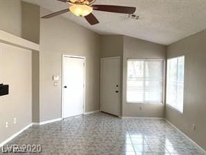 Empty room with lofted ceiling, ceiling fan, and a