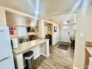 Foyer featuring wood finished floors, a textured wall, and baseboard heating