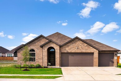 View of front facade featuring a garage, brick si