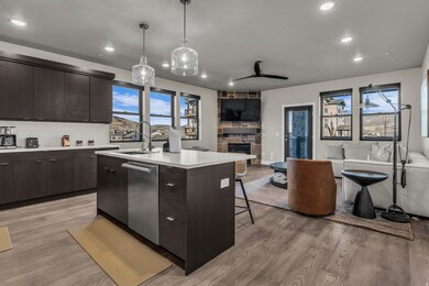 Kitchen featuring modern cabinets, open floor plan, a breakfast bar, a kitchen island with sink, and dark brown cabinetry