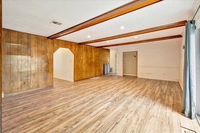 This spacious room features wood panel walls, expo
