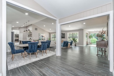 Dining area with vaulted ceiling, dark wood-type 