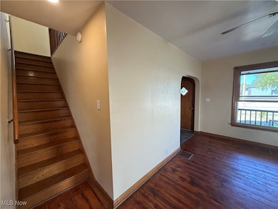 Staircase featuring arched walkways and wood-type flooring