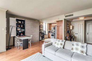View of the kitchen, living/dining from the living space - In lieu of a dining area, the current owner installed a Murphy bed for a feature wall yet accommodate guests when necessary.