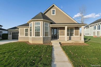 View of front of property featuring brick siding, a porch, a front yard, and a shingled roof