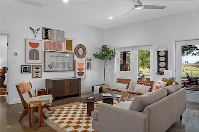 Living room with finished concrete floors, recessed lighting, and a ceiling fan