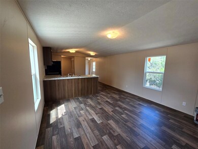 Unfurnished living room featuring dark wood-type 