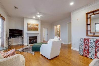 Living room featuring ceiling fan, crown molding, 