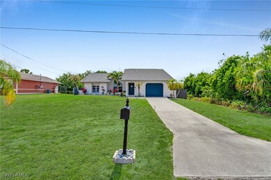 View of front of home featuring a front yard, a ga