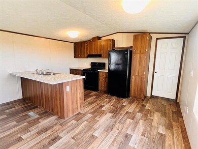 Kitchen with black appliances, light wood-type flo
