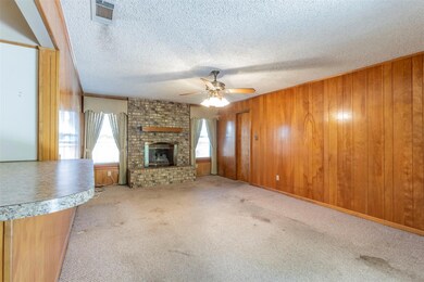 Unfurnished living room with a fireplace, wooden w