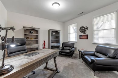 Carpeted office with baseboards and visible vents