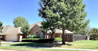 View of front facade featuring brick siding, an attached garage, and roof with shingles